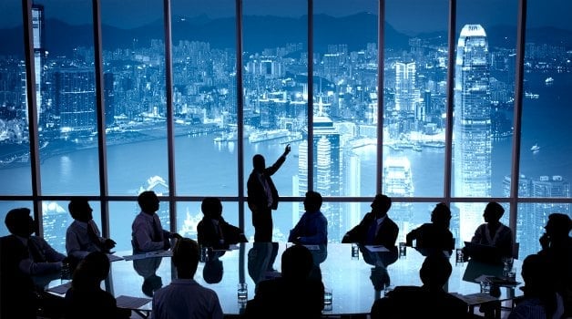 businessmen working at a conference table with hong kong as background