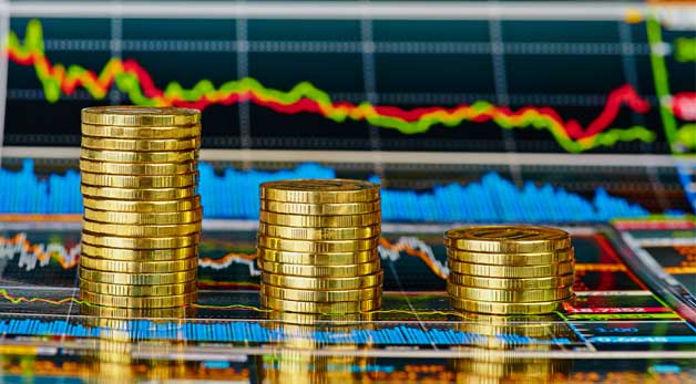 gold coins in front of a stock ticker