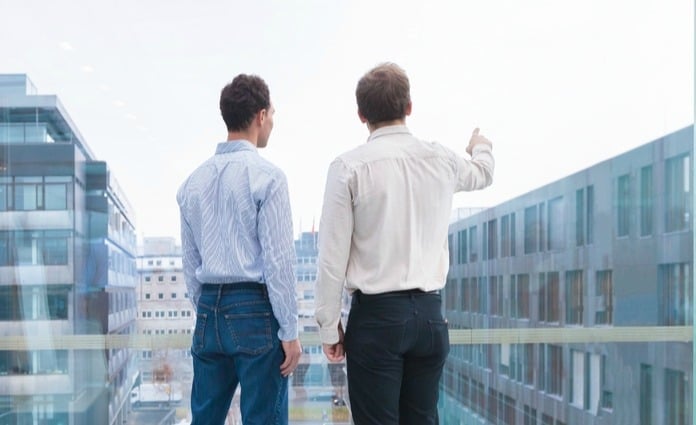 two men looking out towards city