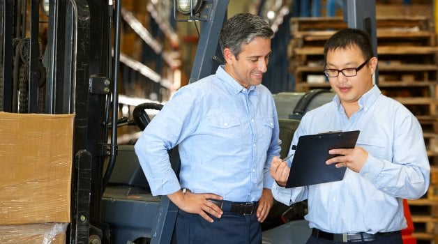 two men discussing at a factory