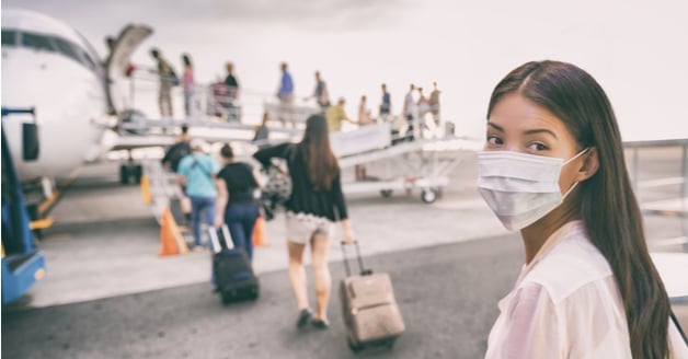 Woman in a mask boarding a plane to China