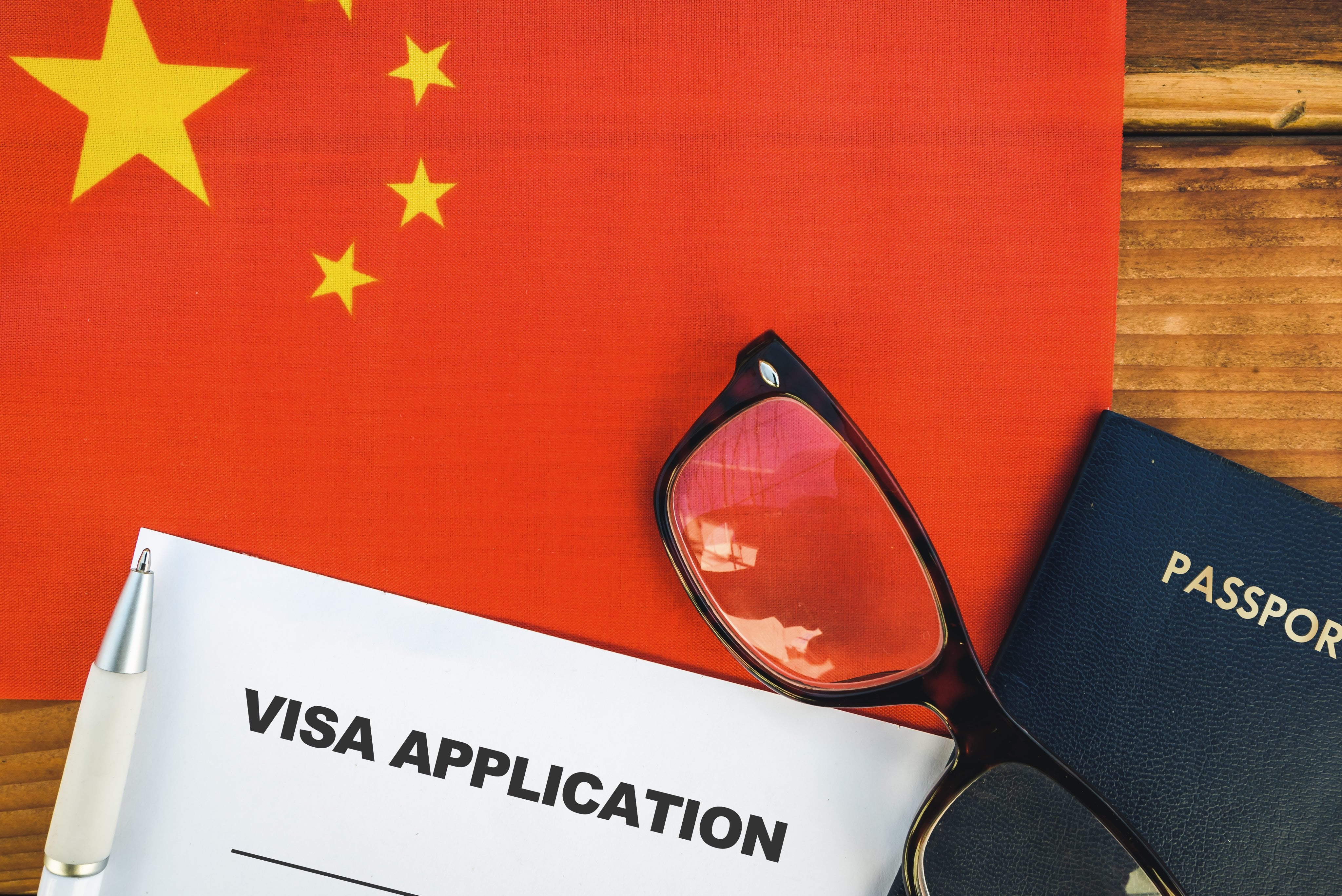A visa application alongside glasses and a passport