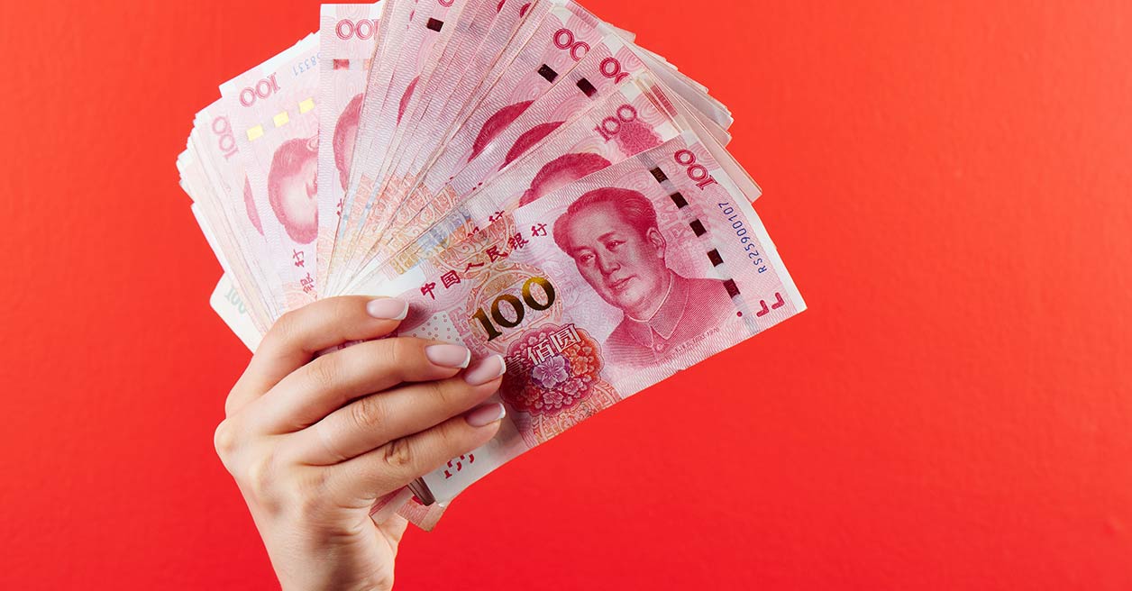 Someone holding up multiple RMB notes