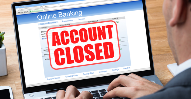Man Using Online Banking Application On Laptop With Account Closed Message On Screen